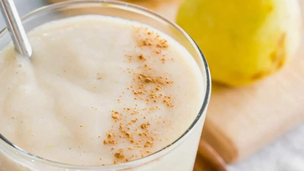 A closeup view of a glass filled with a pear smoothie.