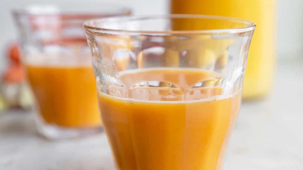 A closeup of two glasses filled with Sunrise Smoothie Boost.