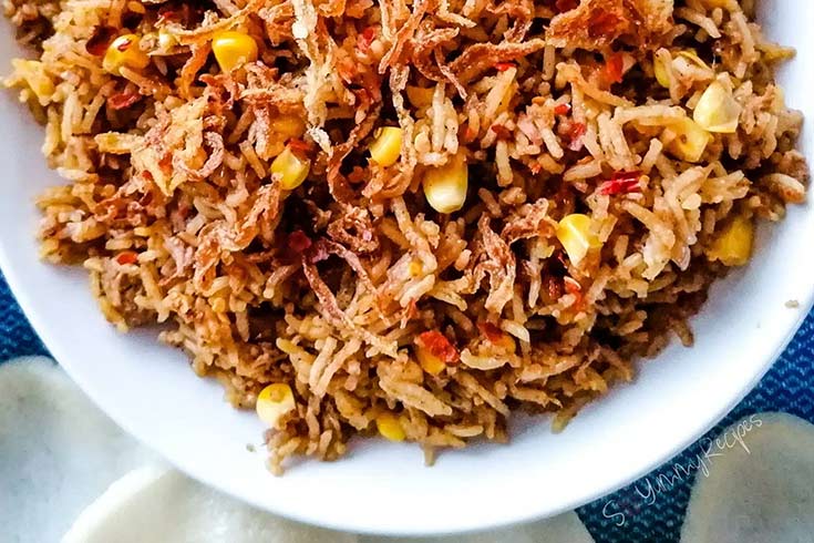 An overhead view of a white bowl filled with Tuna Fried Rice.