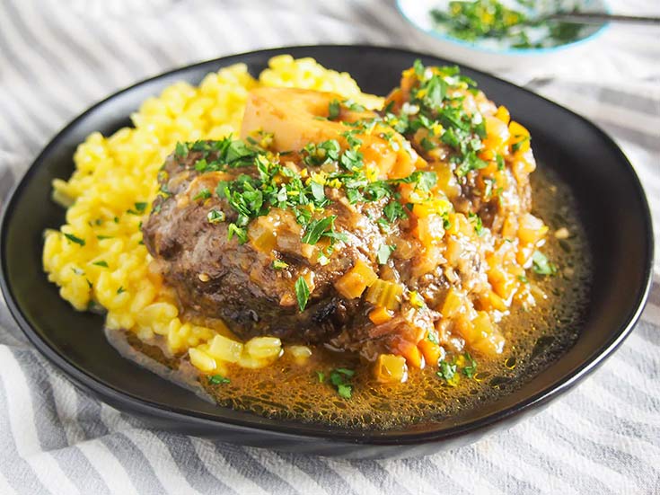 A plate of beef osso bucco over mashed potatoes.