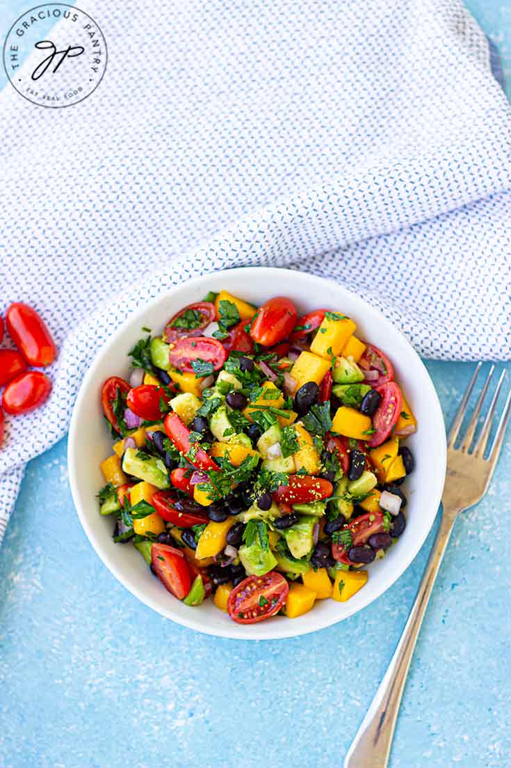 Overhead view of a white bowl filled with black bean salad.
