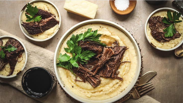 Braised beef served over mashed potatoes in four bowls.