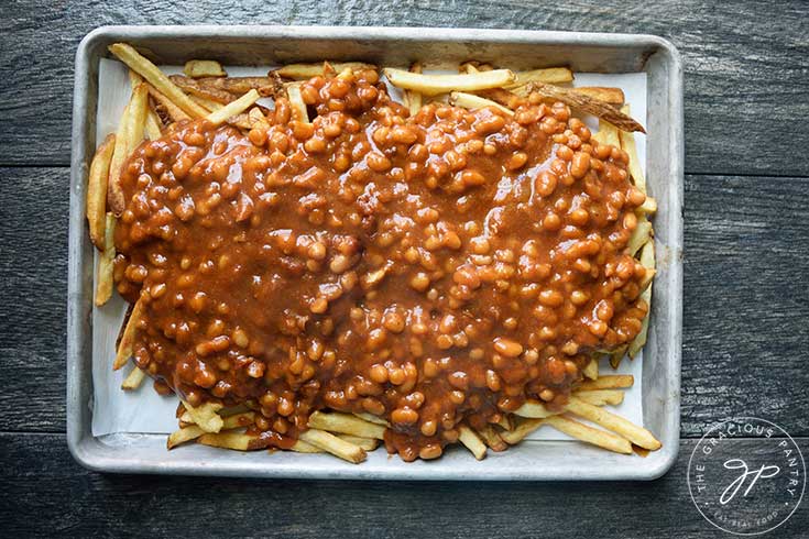 Chili spread over fries on a sheet pan.