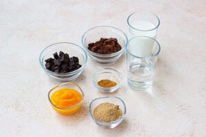 Individual ingredients in small glass bowls on a white surface.