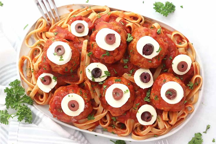 A platter of spaghetti topped with meatballs that look like eyeballs.