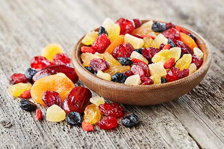 A wooden bowl of dried fruits and berries.