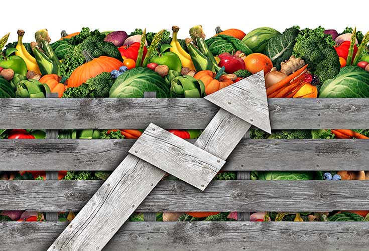 A wooden box of produce with a wooden arrow pointing up.