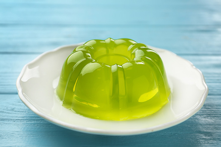 A green jello ring on a white platter.