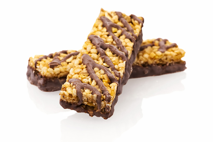 Two granola bars with chocolate drizzle on a white background.