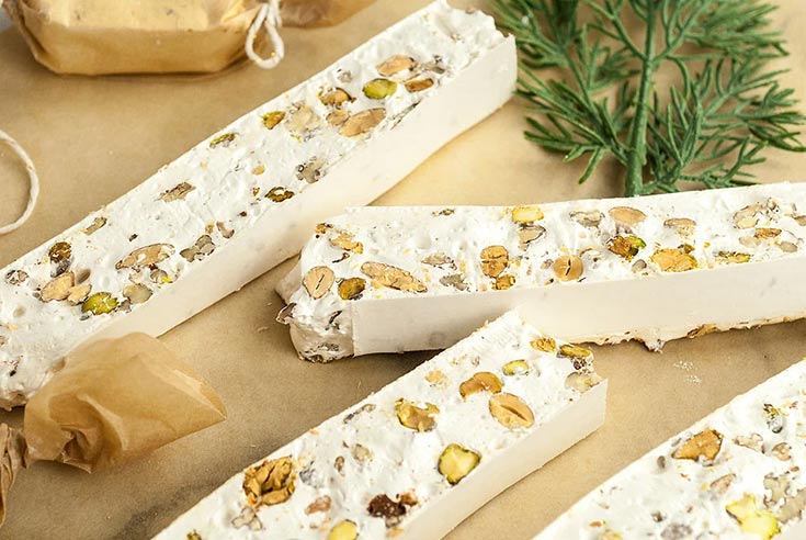 Torrone Italian nut nougat pieces laying on parchment.