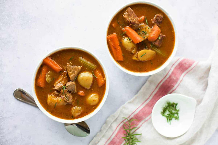 Two white bowls filled with Instant Pot beef stew.