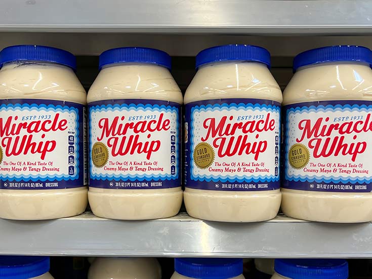 Jars of Miracle Whip on a grocery store shelf.