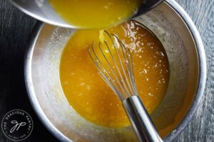 Whisking the melted butter into the wet ingredients.