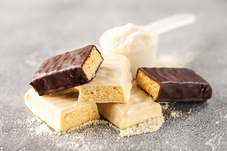 A pile of chocolate and white chocolate covered protein bars.