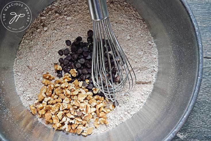 Pumpkin Blondies mix-ins added to the dry ingredients in a mixing bowl.