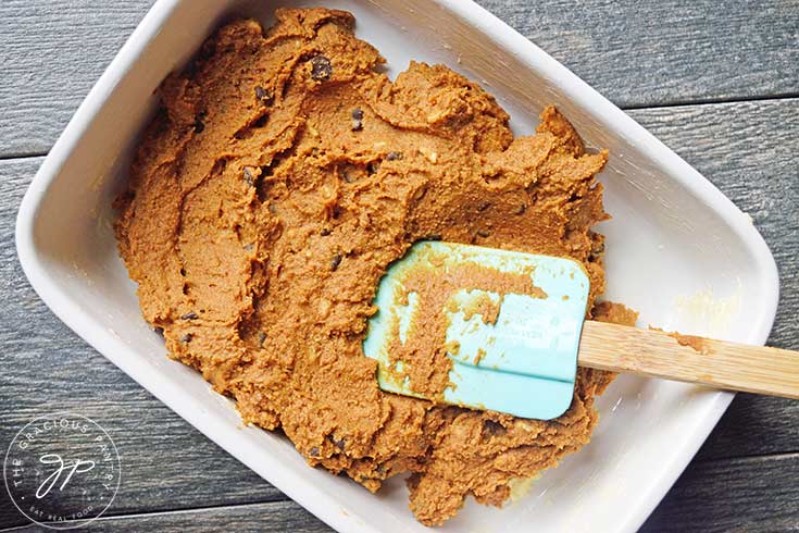 Spreading Pumpkin Blondies batter over the baking dish.