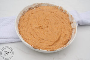 The batter for Pumpkin Donuts mixed together in a white mixing bowl.