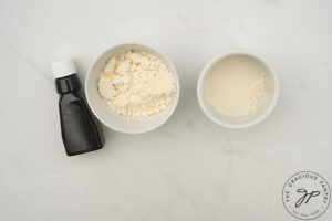 Icing ingredients for Pumpkin Donut glaze on a white surface.