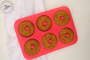 Baked Pumpkin Donut cooling in a donut pan.