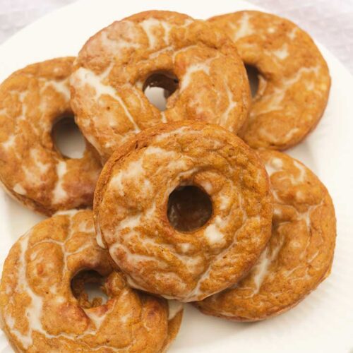 A white plate holds six Pumpkin Donuts.