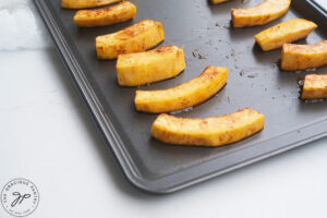 Seasoned pumpkin Fries on a baking sheet.