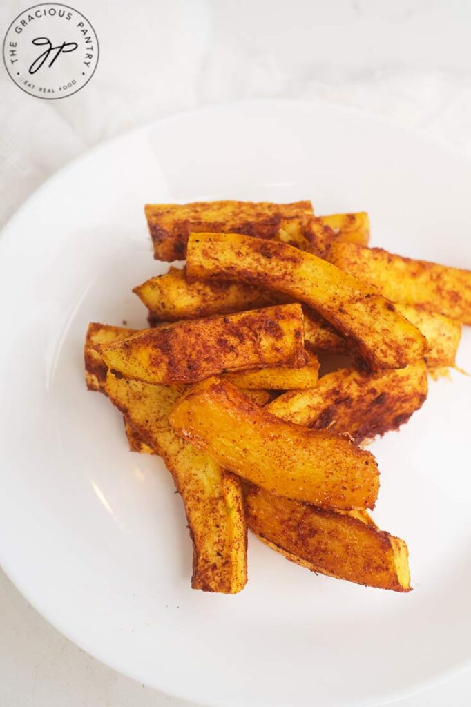 A closeup of a white plate holding a stack of Pumpkin Fries.