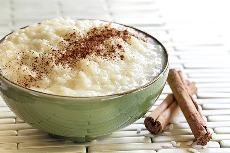 A green bowl filled with rice pudding.