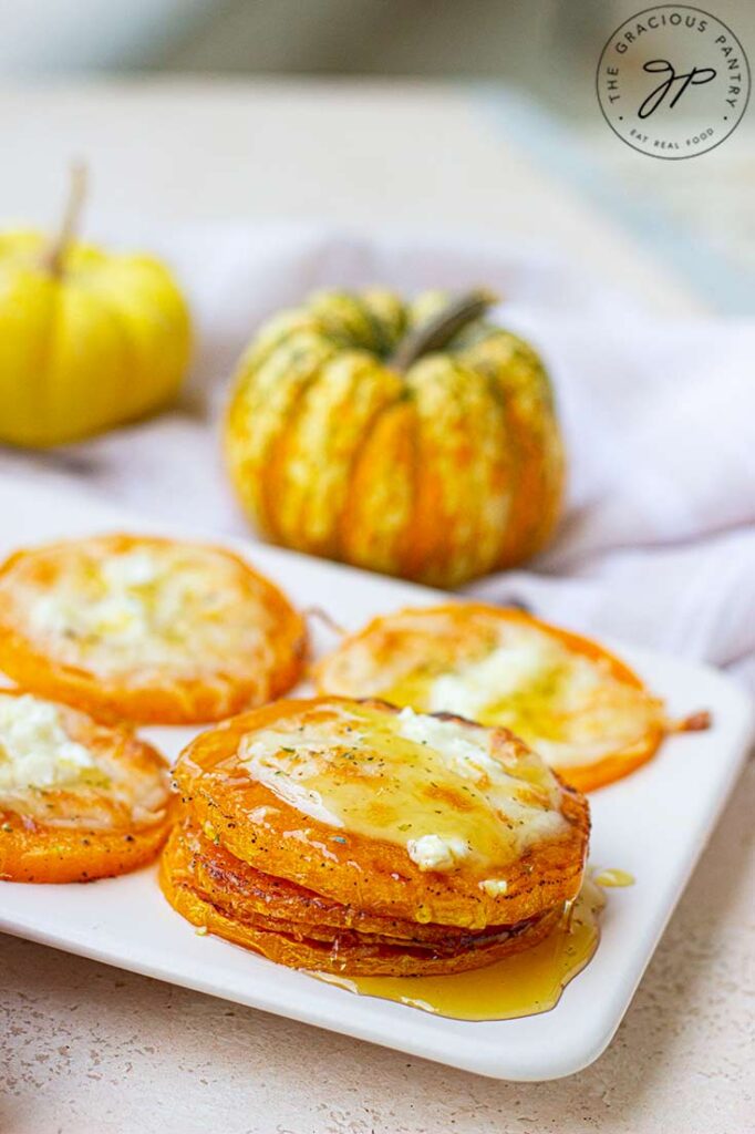 A stack of squash slices on a platter, drizzled with syrup.
