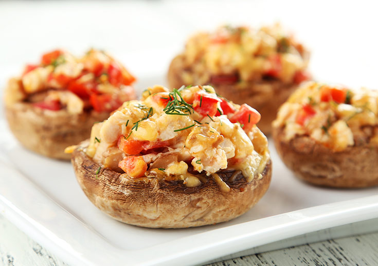 A white platter of stuffed mushrooms.