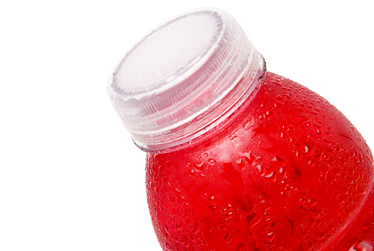 A water bottle filled with pink liquid on a white background.
