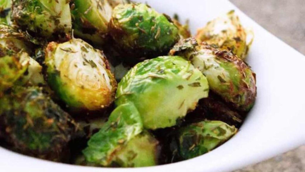 A white bowl of seasoned Brussels Sprouts.