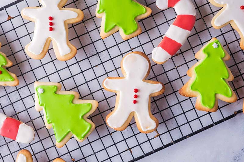 Christmas cookies decorated and sitting on a wire cooling rack.