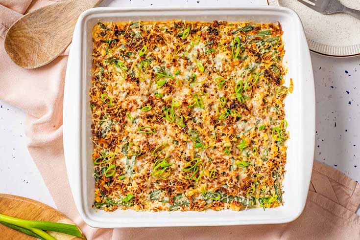 A white casserole dish filled with green bean casserole.