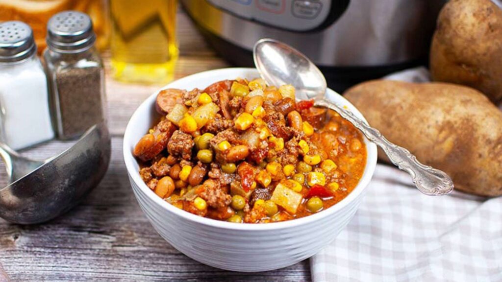 The finished Instant Pot Texas Cowboy Stew Recipe served in a white bowl with a spoon.