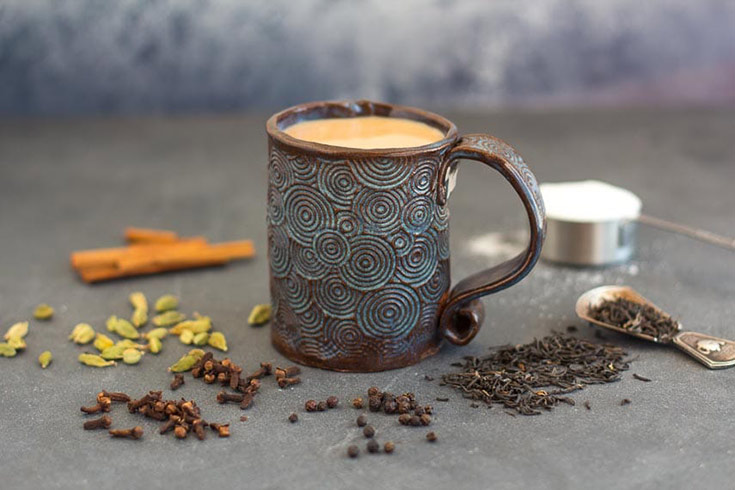A mug of Masala Chai on a gray surface.