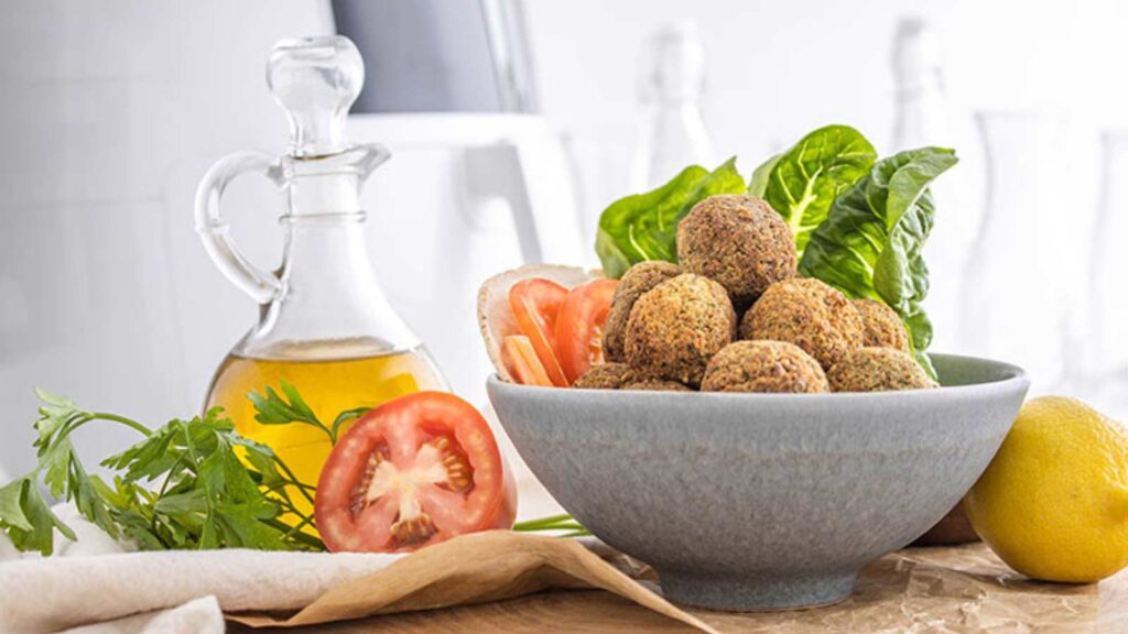 A bowl full of falafel on a table.