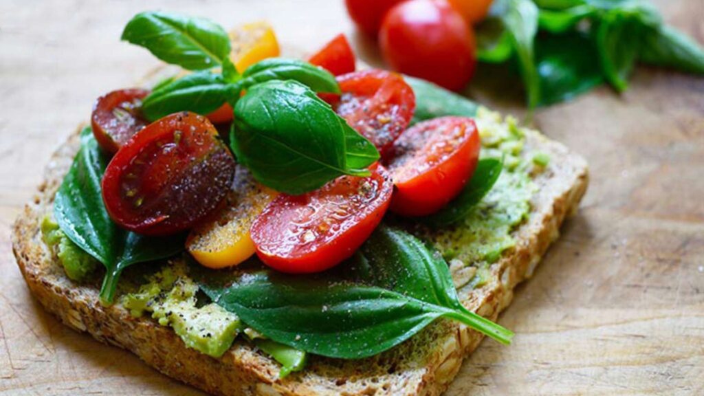 A side view of a single piece of Avocado Toast With Tomato.