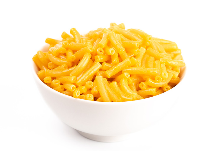 A white bowl on a white background, filled with macaroni and cheese.