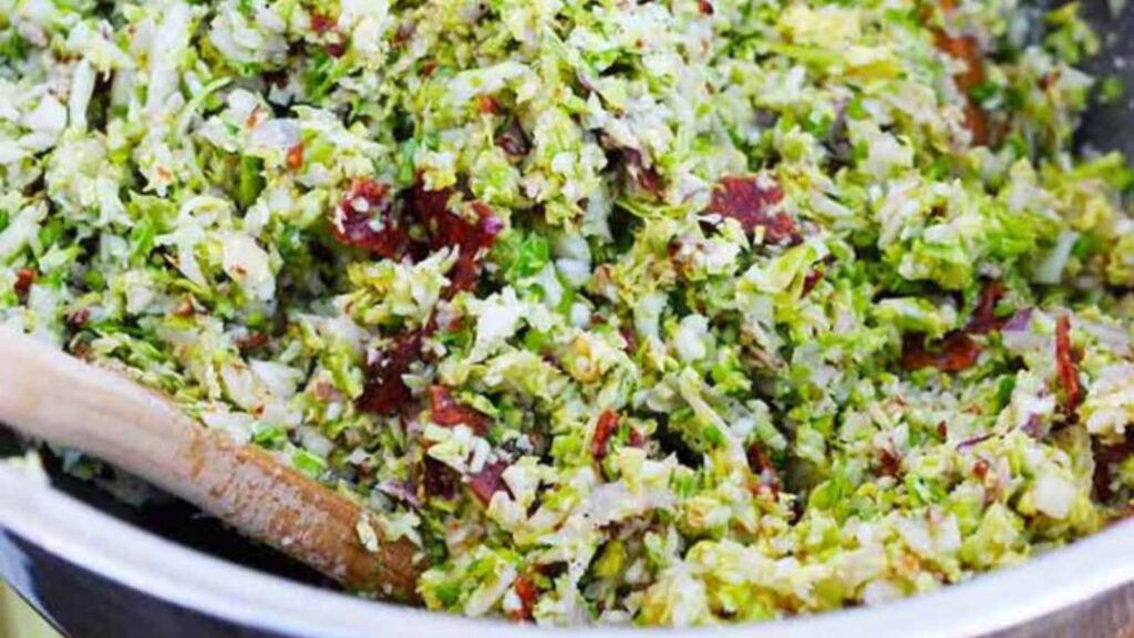 A closeup of a bowl filled with Brussels Sprouts Salad.