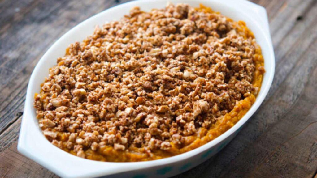 Butternut Squash Casserole in a casserole dish on a wooden surface.