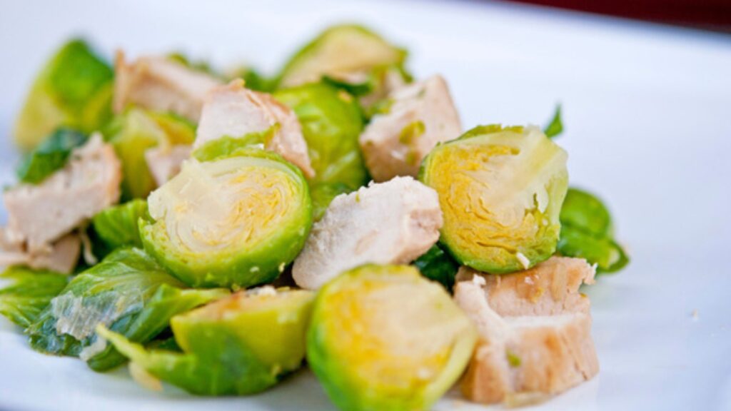 Chicken and brussels sprouts on a white plate.