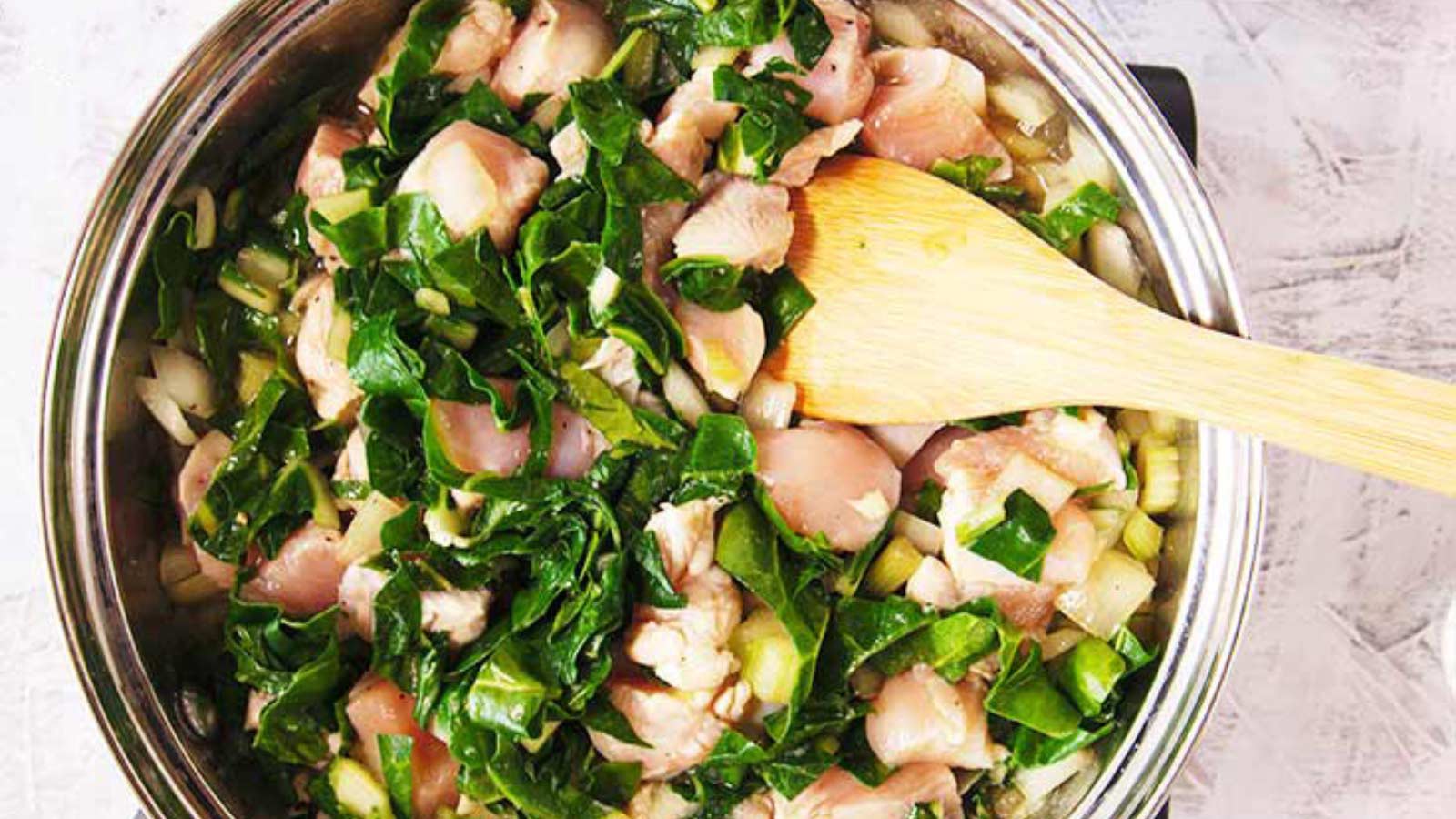 Chicken stir fry cooking in a skillet.