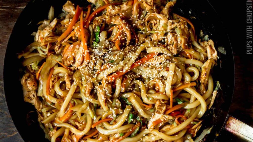 A skillet full of chicken teriyaki yaki udon.