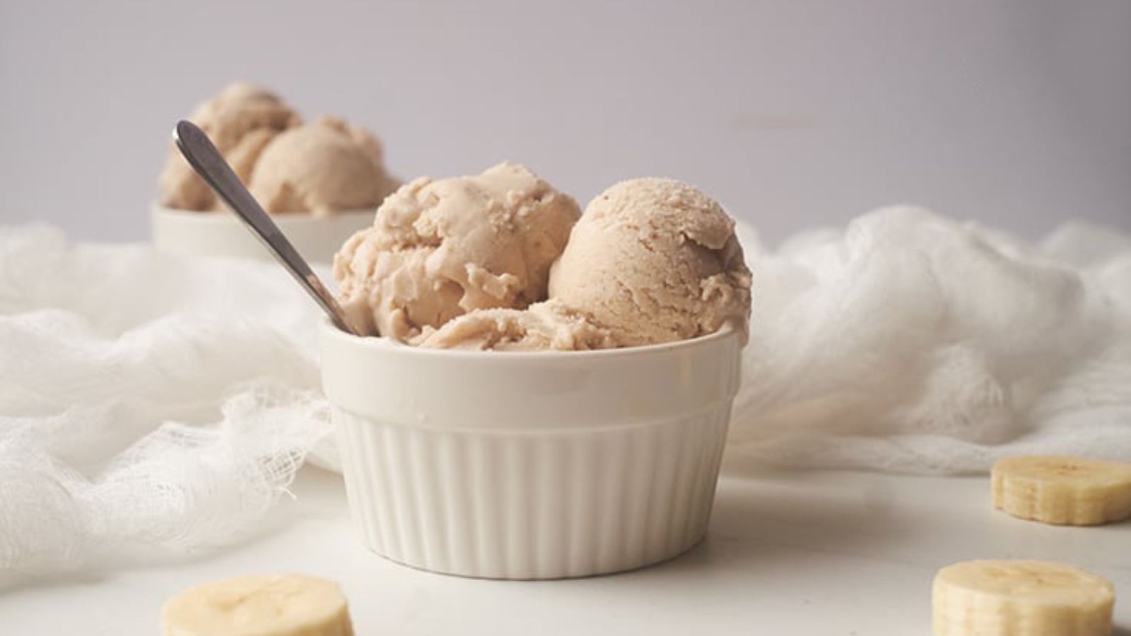 A small bowl filled with scoop of coconut banana N'ice cream. A spoon rests in the bowl.