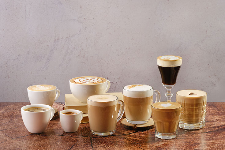 A variety of coffee drinks sitting on a table.