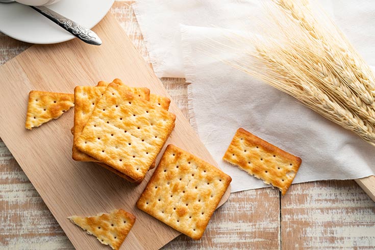 A stack of crackers on a cutting board.