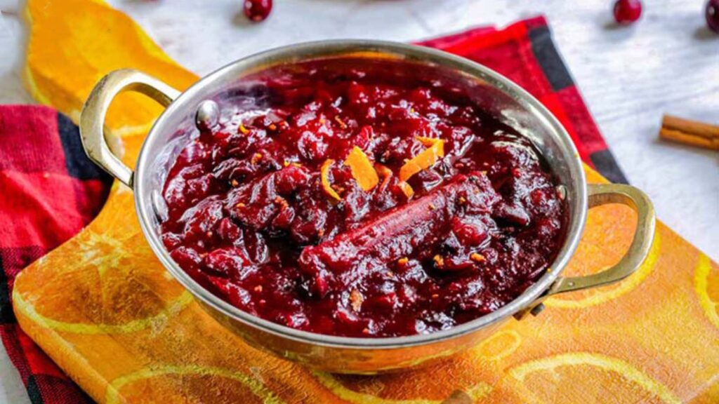 A silver serving bowl of cranberry sauce.