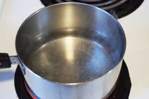 Water in a pot with a pinch of salt, coming to a boil.