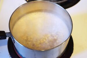 Oats added to water in a pot.