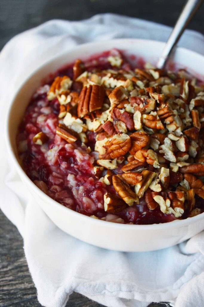 A side view of a white bowl filled with Cranberry Oatmeal.